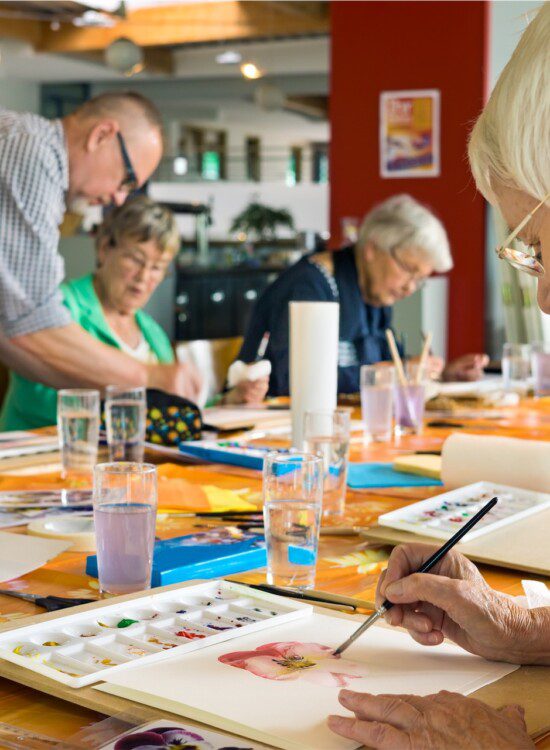 group of seniors paint watercolors during class