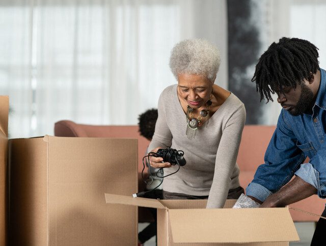 senior woman and her adult son pack her belongings for a move to a senior living community