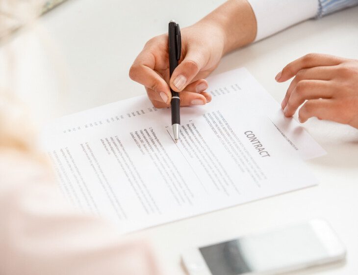 close-up of financial advisor explaining the details of a contract to a senior woman