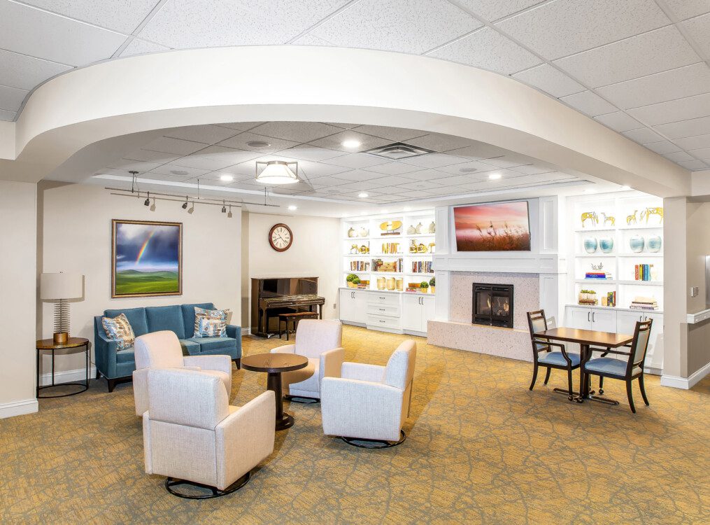 Common space and living room with fireplace at Claridge Court's continuing care and home care building