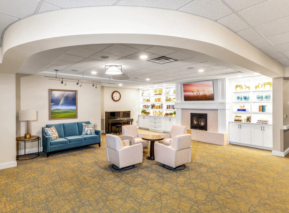 Common space and living room with fireplace at Claridge Court's continuing care and home care building