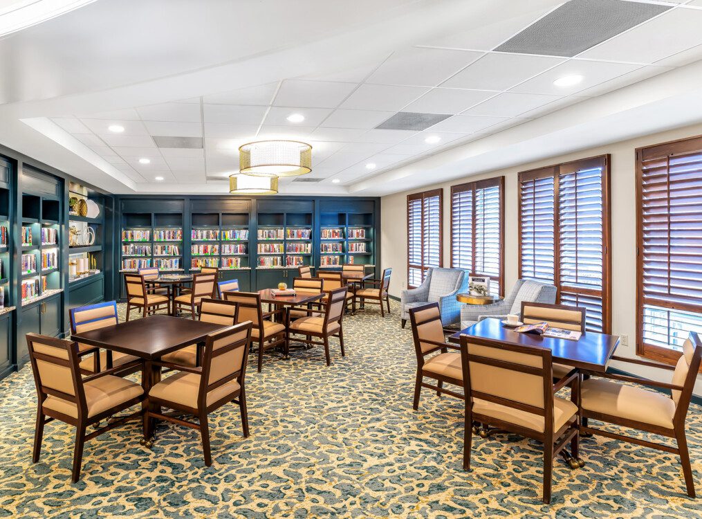 Library and lounge area with ample tables and games at Claridge Court Senior Living Community